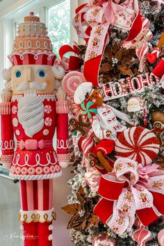 a christmas tree decorated with candy canes and santa clause ornament next to a window