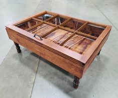 a wooden table with glass top on wheels