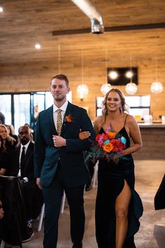 a man and woman are walking down the aisle