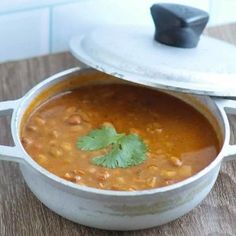 a pot filled with soup sitting on top of a wooden table