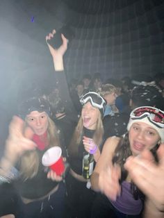 some people are having fun at a party and one is wearing ski goggles, the other has snow goggles