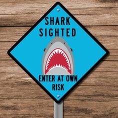 a sign with a shark on it that says, shark signed enter at own risk