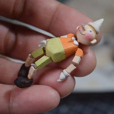 a person holding a small toy in their hand