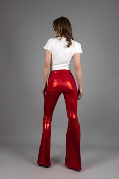 "All eyes will be on you as you perform in these red-hot leggings with flared legs. They are made with mystique spandex to give you the stretch you need to show off your moves on stage. You'll be comfortable in the high waist with 4 cm wide elastic. The back has a V-cut shape with pockets, while the front is solid red. Features: * Tight-fit * Slip-on * High waist * Bell bottom legs * Shiny red mystique spandex, 80% nylon, 20% spandex * V-cut shaped back & pockets * Solid red front * 4 cm wide waistband * 4-way stretch * The model is 179 cm and wearing a size XS x 36\" * Fits true to size. Take your regular size. Available in size XS-XXL. Hip measurement (measures on the actual hip bone:/low waist): XS: 75-80 cm / 29,5\" - 31,5\" S: 81-86 cm / 31,8\" - 33,8\" M: 87-92 cm / 34,2\" - 36,2\" L Red Fitted Full Length Bottoms, Fitted Full-length Red Bottoms, High Stretch High Waist Red Pants, High Stretch Full Length Red Leggings, High Waist High Stretch Red Pants, High Stretch Red Party Bottoms, Red High Stretch Bottoms For Party, High Stretch Red Bottoms For Party, Full-length Red Elastane Pants