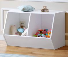 a white cubby with stuffed animals and toys in it's storage compartment on the floor