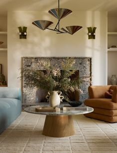 a living room with two couches and a table in front of a fire place