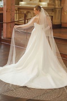 a woman in a wedding dress with a veil on her head