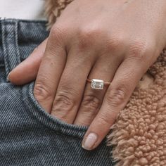 a close up of a person's hand with a ring on their finger,