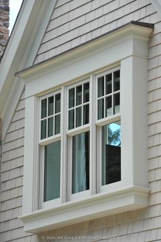 an image of a window on the side of a house that is white and has black trim