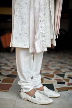 Ivory woven sherwani with mandarin collar, all over mixed pattern, sequin and tonal thread embroidery. Paired with cotton silk kurta, churidar and stole with embroidered border.
Components: 4
Pattern: Embroidered and Woven
Type Of Work: Thread and Sequin Work
Neckline: Mandarin Collar
Sleeve Type: Full Sleeves
Fabric: Cotton Silk, Lining: Viscose Poly
Color: Ivory
Other Details: 
Front and side slits
Attached lining
Sherwani Closure: Front concealed placket
Note: The safa, kalangi and mala worn White Traditional Sherwani, White Dabka Sherwani Traditional Fit, White Transitional Sherwani With Traditional Fit, Transitional White Sherwani With Traditional Fit, Traditional Off-white Kurta With Naqshi, Traditional Off White Kurta With Naqshi, Off White Naqshi Bandhgala, White Traditional Wear With Naqshi On Straight Kurta, White Traditional Wear With Naqshi Embroidery