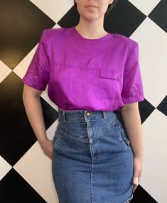 Vintage 1980s bright purple shell shirt- still has the shoulder pads! The top has a simple bpxy cut with short sleeves and crewneck. On the front, there is a small fake pocket design, but the pocket is not functional. Bottom hem has a jersey ruching for better tucking in. The only closure is a button in the back of the neck. No tags, but I am thinking it is a size medium. In excellent condition, just a little fading in the jersey hem.  Measurements (in inches, laying flat): Width: 21 Length: 25 Bright Purple, Shoulder Pads, Womens Clothing Tops, Shirt Blouses, Blouses For Women, Violet, Shells, Short Sleeves, Tops & Tees