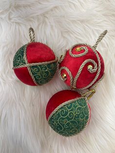 three red and green ornaments on white fur