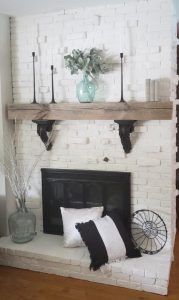 a white brick fireplace with black and white pillows