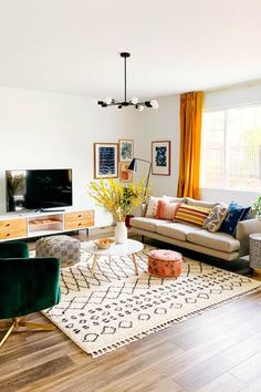 a living room filled with furniture and a flat screen tv on top of a wooden floor