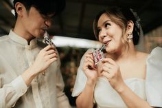 a bride and groom are holding up some kind of chocolate bar in front of each other