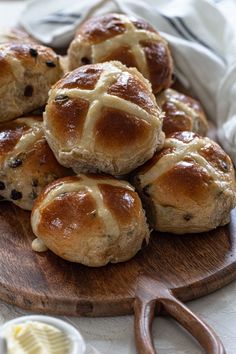 hot cross buns on a wooden cutting board