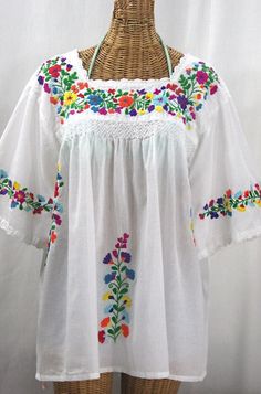 "* Ornate hand embroidery and smocking with hand crocheted trim on the neck and open sleeve hems, available here in WHITE with MULTICOLOR RAINBOW embroidery + WHITE trim. * Light, gauzy and semi-sheer 100% cotton throughout; wear it billowy and flowing in the bohemian style, or belted for a more fitted look. * Dyed, distressed  and embroidered by hand for an authentic, retro-vintage and boho-chic hippie vibe.  * Our colorful and ornate floral embroidery patterns are a faithful tribute to the tra White Folk Peasant Top For Festival, White Folk Embroidered Top With Embroidered Hem, Multicolor Floral Embroidery Peasant Top, Multicolor Floral Embroidered Peasant Top, White Folk Style Embroidered Top, White Bohemian Peasant Top With Intricate Embroidery, White Peasant Embroidered Top, Peasant Top With Multicolor Embroidery And Embroidered Hem, Multicolor Embroidered Peasant Top