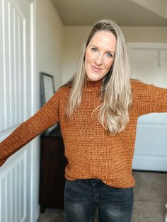 a woman standing in the hallway with her arms outstretched