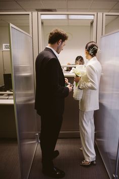 a bride and groom are standing in an elevator