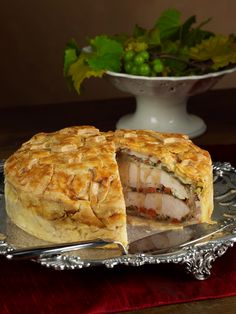 a meat and vegetable pie on a silver platter