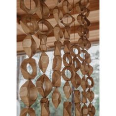 a wooden wind chime hanging from the ceiling in front of a window with lots of circles on it