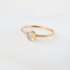 Our dainty Moonstone Ring features an absolutely stunning natural stone with reflects of blue. Moonstone is the birthstone for all our June-born babes. Don't know your ring size? Ring Size Guide or Buy Ring Sizer …………………………………. Details: Stone is Natural Rainbow Moonstone measuring 5mm Available in 14k Gold Filled or Sterling Silver Waterproof and can be worn everyday Size Inclusive and made to order About Your Jewelry If you are not wearing your jewelry it is best to store it in a cool, dry plac