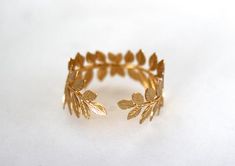 This stunning bracelet is decorated with two beautiful and detailed olive leaves. The bracelet is adjustable so one size fits all.The Olive Leaf symbolizes beauty, peace and prosperity, and it represents Athena, Greek goddess of wisdom. In other words, this is a powerful piece for powerful women.Measurements: the diameter is around 15cm / 6inch.* Comes wrapped in a pretty gift package.* Could be requested in either 14k gold, rose gold or silver plated brass..For updates, new products, one-of-a-k Handmade Gold Nature-inspired Bracelets, Elegant Adjustable Leaf-shaped Jewelry, Bohemian Gold Leaf Jewelry, Greek Cosplay, Greek Goddess Bracelet, Greek Accessories, Gold Leaf Jewelry, Leaves Bracelet, Ancient Greek Jewelry