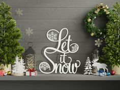 christmas decorations are displayed on a mantle with the words let it snow written in white