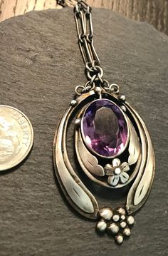 "Sterling  Amethyst handwrought studio Art Nouveau necklace.  Circa early 1900s.  Condition I see no problems any slight wear commensurate with age-pictures show design details.  Length of necklace 15\", more links can be added if desired, pendant drops from chain approx. 2\" by 1 1/8\", the oval faceted Amethyst is approx. 16mm by 12'' and bezel set.  Interesting construction -overlaid silver elongated  leaves give sweeping movement, with flower and abstract bead bubbles at base, graceful class Vintage Purple Round Jewelry, Antique Purple Collectible Jewelry, Vintage Purple Hallmarked Jewelry, Antique Oval Amethyst Necklace, Antique Hallmarked Purple Necklace, Antique Purple Hallmarked Necklace, Antique Hallmarked Purple Necklaces, Antique Purple Hallmarked Necklaces, Vintage Amethyst Pendant Jewelry