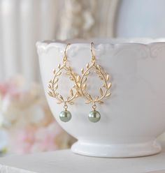 "Gorgeous gold plated laurel wreath and sage green pearl earrings. Tarnish resistant gold plated laurel wreath pendants have beautiful details on both front and back, with beautiful sage green glass pearls dangling below, hang from tarnish resistant gold plated over brass French hook ear wires. Total length: approx. 2.2\" (58mm) Laurel wreath: 25mm x 30mm Sage green pearl: 8mm More sage green pearl earrings are available here: www.etsy.com/lechaim/listing/249731049 www.etsy.com/lechaim/listing/1 Sage Green Necklace Quince, Sage Green Earrings, Gold Laurel Wreath, Green Pearl Earrings, Wedding Earrings Chandelier, Prom Outfit, Bridal Earrings Chandelier, Green Themed Wedding, Wedding Chandelier