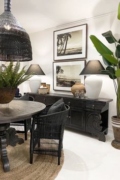 a dining room table surrounded by chairs and plants