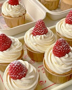 cupcakes with white frosting and strawberries on top