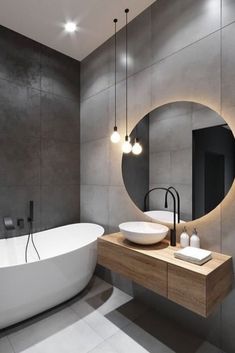 a bathroom with a bathtub, sink and round mirror in it's center