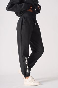 Elevate your everyday style with our Oversized Tapered Joggers, a perfect fusion of relaxed comfort and refined design. Tailored for a slightly oversized fit, these joggers feature ribbed cuffs and waistband for a flattering, secure silhouette. Subtle tonal printing along the side leg adds a touch of sophistication, while functional front pockets offer practical storage. Made from a soft cotton blend, these joggers are perfect for lounging or casual wear. Pair them with a crisp white shirt for a Black Jogging Pants With Elastic Cuffs, Loosely Fitted Tapered Leg Sweatpants With Elastic Side Panels, Trendy Jogging Pants With Elastic Cuffs, Trendy Relaxed Fit Jogging Bottoms, Trendy Relaxed Fit Bottoms For Jogging, Ankle-length Joggers With Ribbed Waistband, Athleisure Straight Joggers With Ribbed Waistband, Sporty High-waisted Cotton Joggers, Relaxed Fit Sportswear Pants