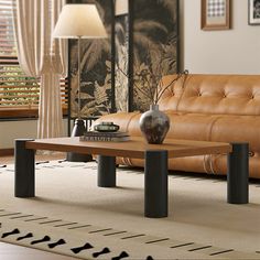 a living room with leather couches and a coffee table in front of a window