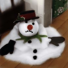 a snowman with a hat and scarf on it's head sitting in the middle of a room