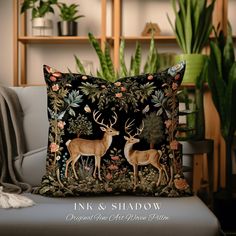 a decorative pillow with two deers in the forest on it, surrounded by greenery