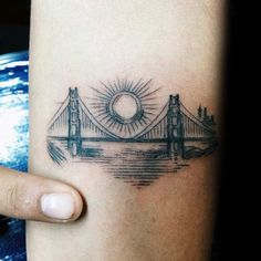 a woman's arm with a tattoo on it that shows the golden gate bridge