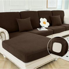 a brown and white couch sitting on top of a wooden floor next to a rug