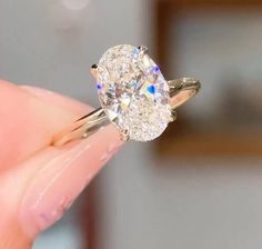 a close up of a person holding a diamond ring