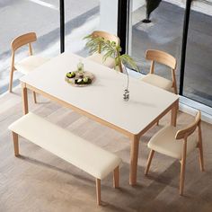 a white table with four chairs and a potted plant on it in front of a window