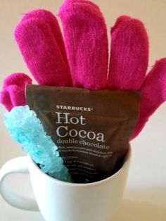 hot cocoa in a coffee cup with pink gloves