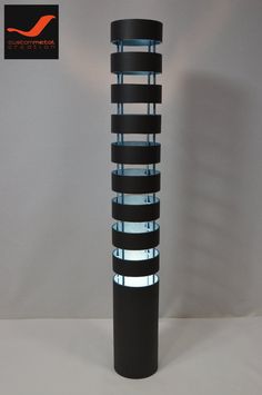 a tall black and white lamp sitting on top of a table