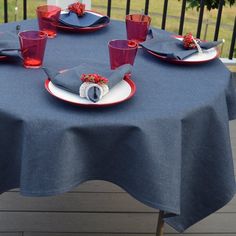 the table is set with blue linens and red glassware