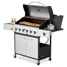 an outdoor grill with food cooking on the top and side burners, including hot dogs