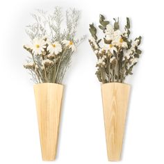 two wooden vases with white flowers and greenery in them on a white background