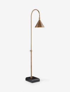 a lamp that is on top of a black base and has a gold metal shade