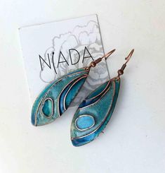 This is a blue cloisonne enamel pendant designed by a hungarian artist, Diana Páthi. Dimensions: The leaf shaped pendants are 5.5 x 2cm + hooks are 1.5cm long. For extra you can order 925sterling silver hooks. Here is the link: https://www.etsy.com/listing/274041444/925-sterling-silver-extra-earring-hooks?ref=shop_home_active_1 Fired cloisonne enamel is a beautiful traditional material for making jewelry. First I cut out the copper pieces, than I form it to a shape I want. After a sandpaper cleaning I put the handformed wire ornaments and I take transparent enamel and colours. During the process I fire the piece at high temperature for three or four times, It depends of the form and the colour I want. I do nearly the same way as ancestors made 4000years before. At the and I clean and polis Elegant Turquoise Enamel Earrings, Blue Hand Painted Jewelry Gift, Blue Metal Earrings For Gift, Blue Hand Painted Jewelry As A Gift, Nickel-free Blue Enamel Jewelry, Light Blue Metal Earrings For Gift, Hand Painted Blue Jewelry For Gifts, Blue Hand Painted Jewelry For Gift, Light Blue Metal Earrings As A Gift