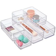 three clear drawers with makeup and other items in them on top of each other,