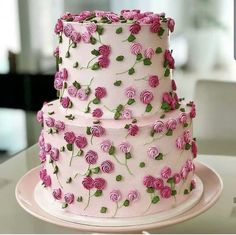 a three layer cake decorated with pink roses